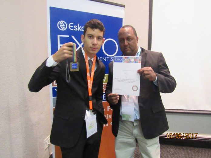 Professor Giezi Américo Reginaldo e seu aluno Izaias Diniz França Neto exibem medalha conquistada na África do Sul
