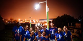 Voluntários Litro de Luz comemoram a chegada de mais um poste em comunidade carente. Foto - Litros de Luz - Divulgação