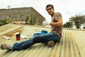 Vitor Belota prepara garrafa pet para ser instalada em residência sem energia elétrica. Fotos - Litros de Luz - Divulgação