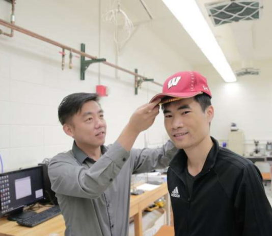 Professor Xudong Wang, especialista em engenharia de materiais da UW-Madison, testa boné em usuário. Foto: UWM