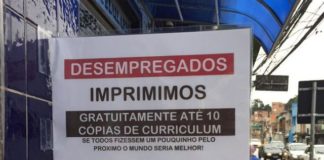 Em frente à Papelaria do Alemão, placa informa que desempregados podem imprimir currículo de graça. Foto - Facebook - Danilo Rafael