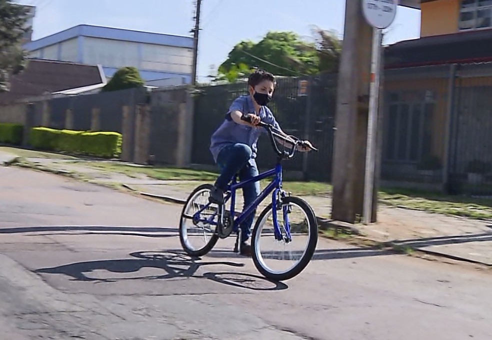 Benício na bicicleta que acabou arranhando o carro do vizinho. Foto - Reprodução/RPC