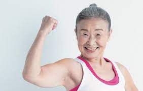 Divertida, a professora Takimika, 90 anos, exibe seus músculos