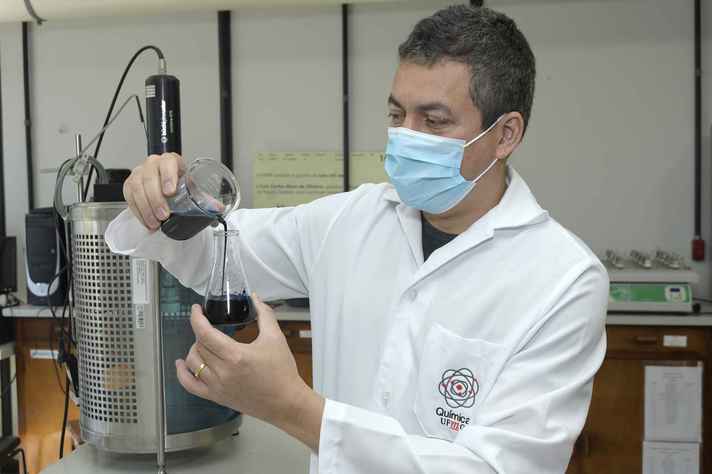 Professor Luiz Carlos Oliveira com a solução que dá origem ao fungicida, que usa nanopartículas de nióbio. Foto - Foca Lisboa | UFMG