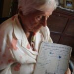 Vovó Cocota com seu caderno de preciosidades dos anos de 1930. Imagem gerada por IA